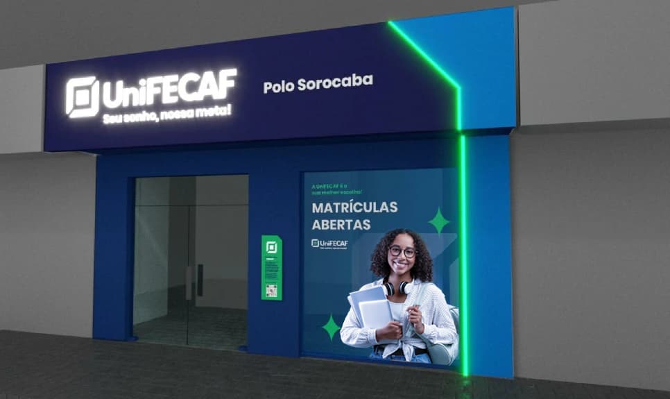 Visão externa do portão de entrada de um polo da UniFECF, uma parede com tons de azul e uma luz verde neon contronando e dando forma para a parede