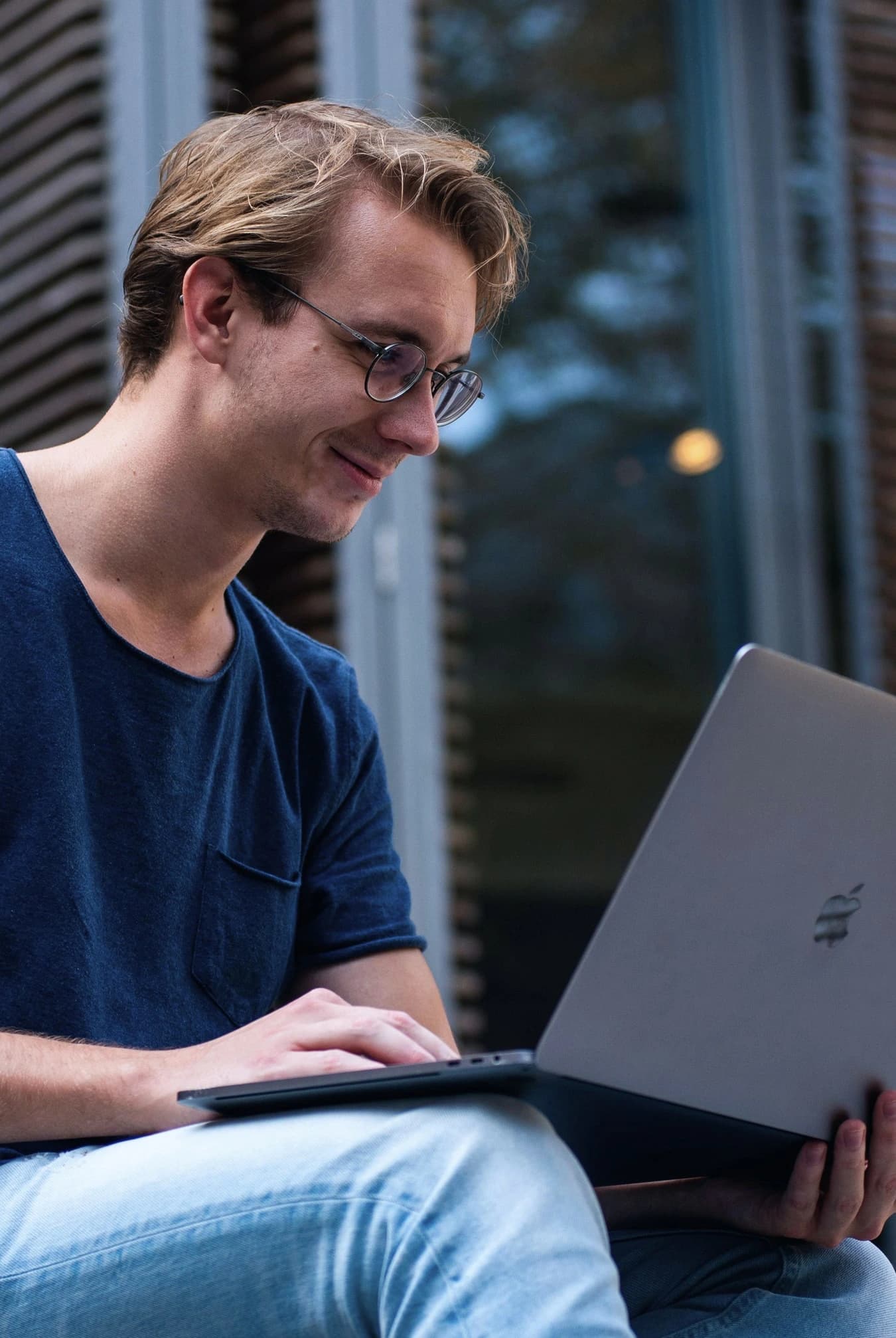 Homem sorrindo mexendo no computador